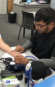 male student practicing vitals