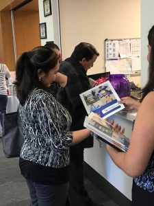 meet and greet check in, male signing in and female receiving folder