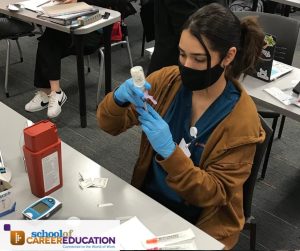 Student practices syringe draw